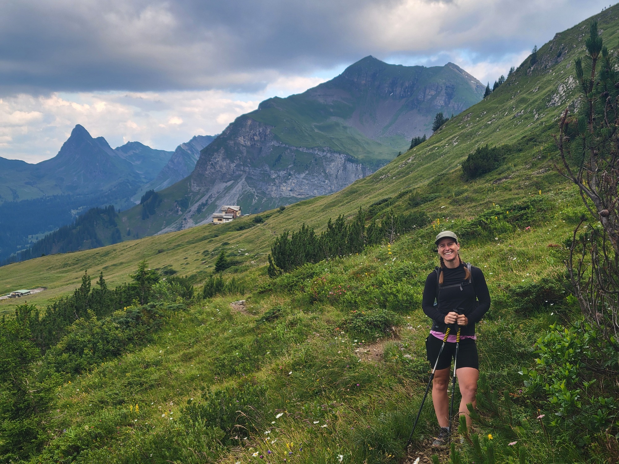 Randi on the grassy planes under a the swiss mountains